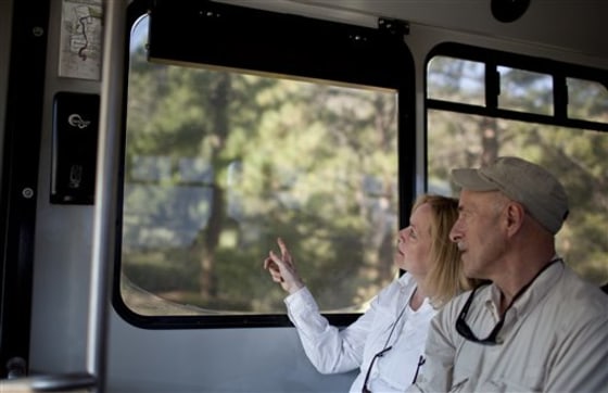 Terry and Gary Steinhoff look out a shuttle window at Bandelier National Monument, N.M. After being closed because of the state's largest wildfire on June 27 and the threat of floods, the main archeological sites in Frijoles Canyon reopened Monday.